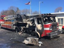 A fire truck that has been completely destroyed by fire, burned to a charred shell